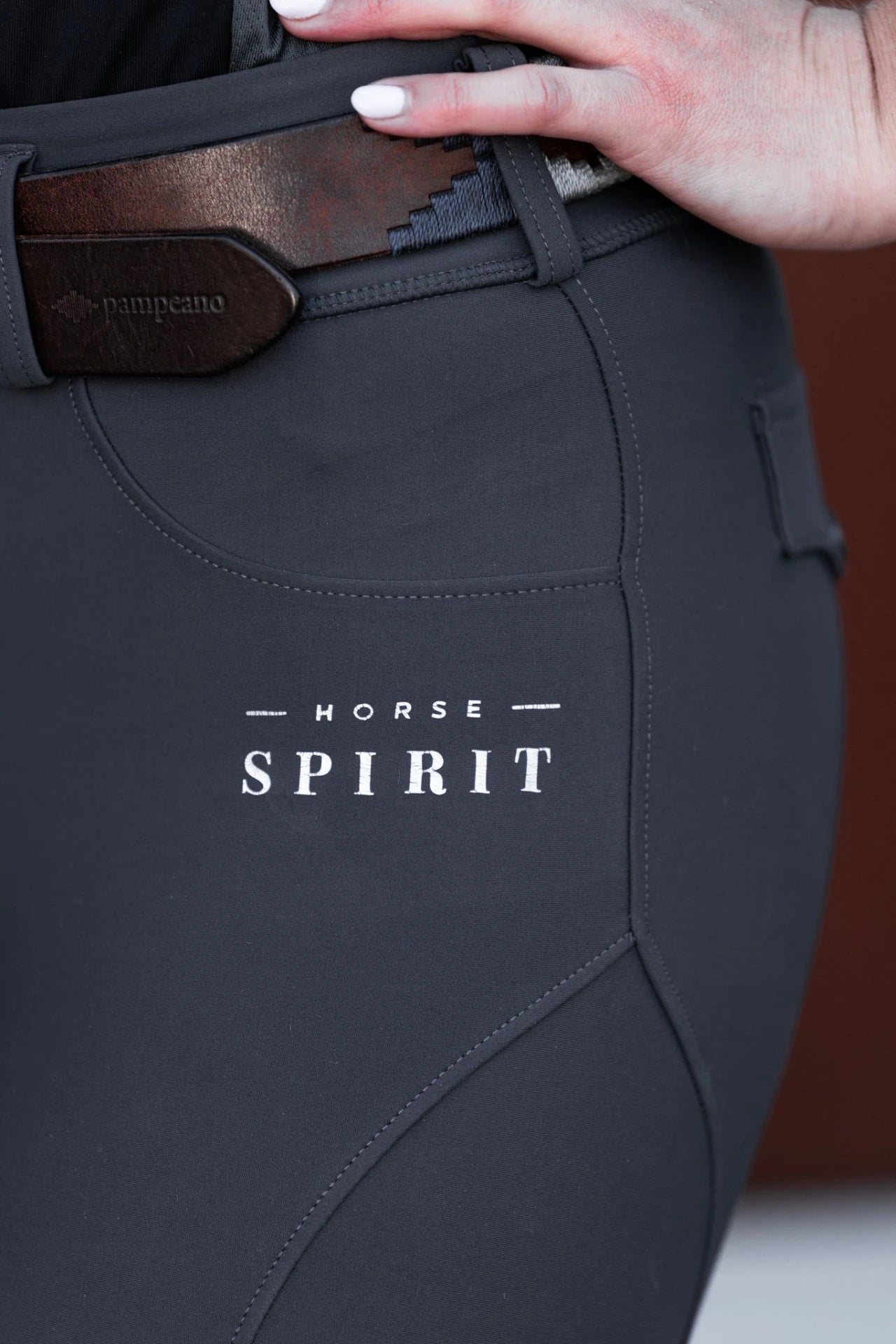 Close-up of the Horse Spirit logo printed on the grey riding leggings.