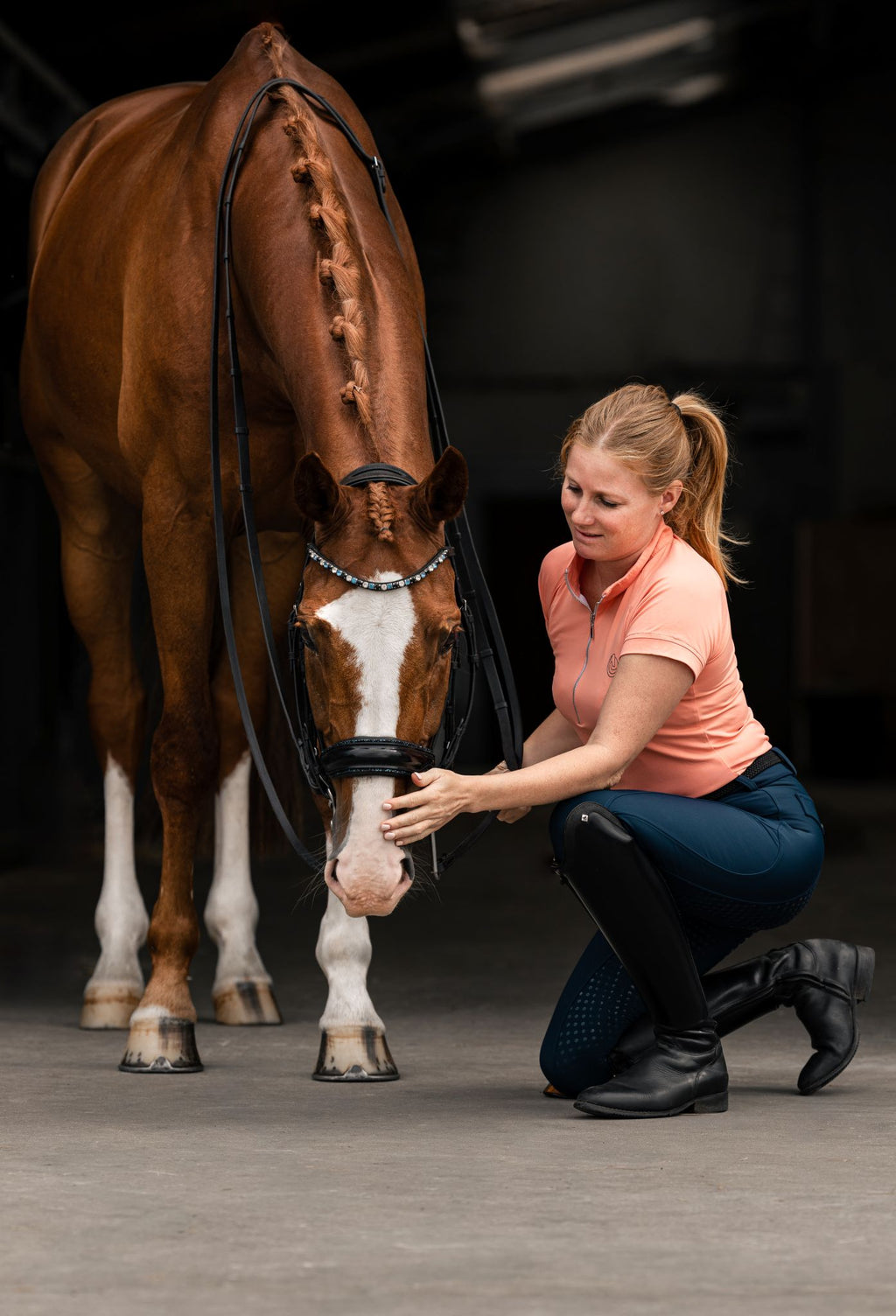 Horse Spirit Basic Riding T-Shirt in peach - Side view on model in action showing the athletic fit, iconic HORSE Spirit logo, and breathable performance fabric.