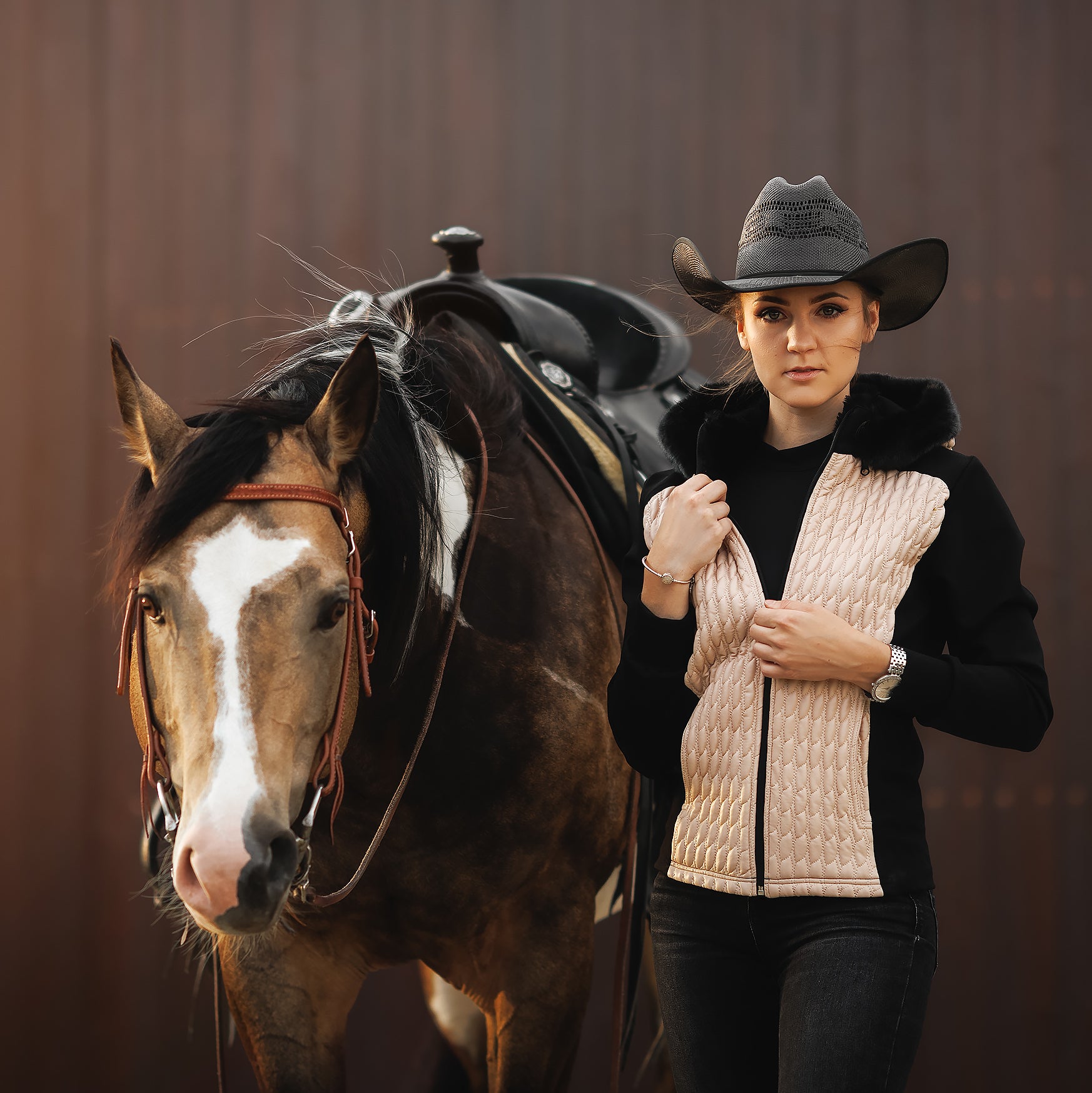 Horse Spirit Riding Jacket in action - Equestrian rider in beige and black jacket with hood, showcasing stylish warmth and freedom of movement.