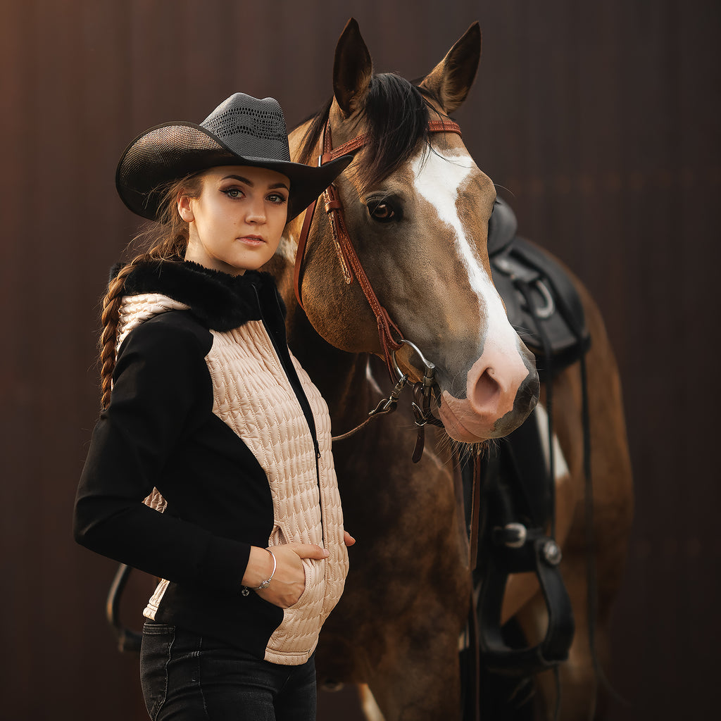 Horse Spirit Riding Jacket in action - Equestrian rider in beige and black jacket with hood, showcasing stylish warmth and freedom of movement.