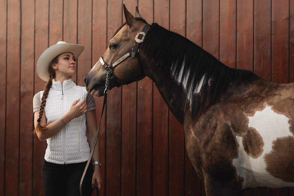 Horse Spirit White Bodywarmer in action - Equestrian rider in white bodywarmer with faux fur collar, showcasing elegant warmth and performance.