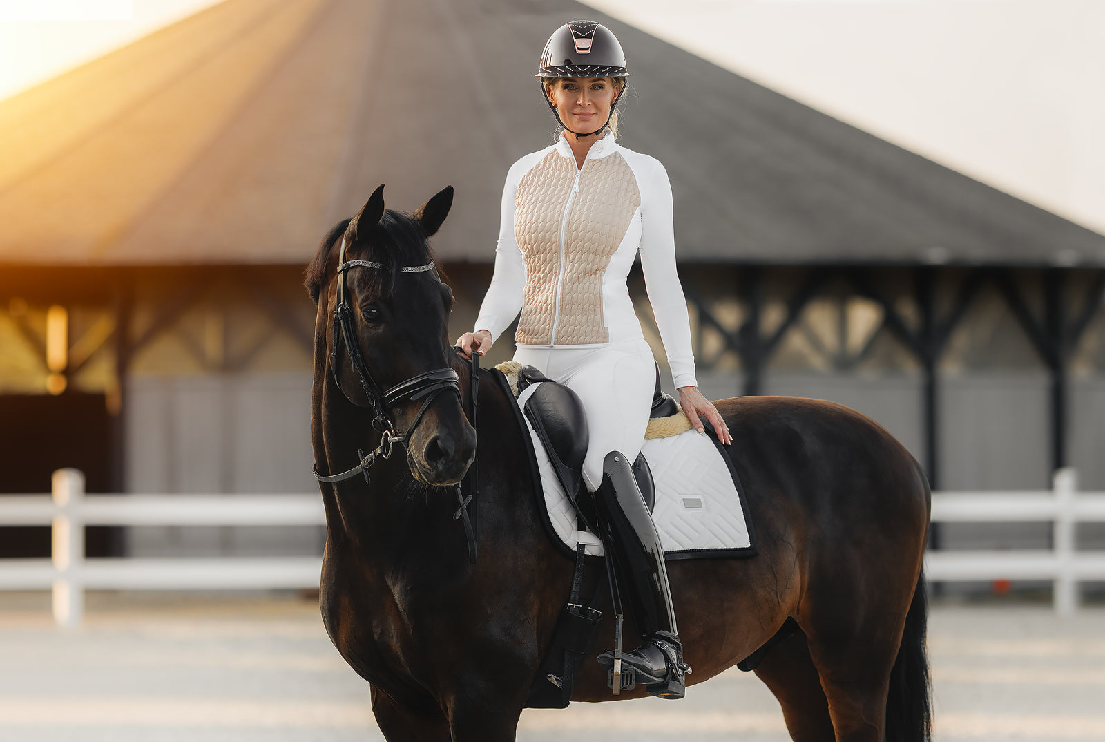 Show ring ready – female competitor in Horse Spirit white hybrid jacket on horseback, combining elegance with advanced breathability and warmth.