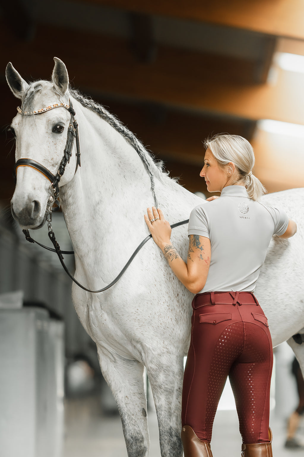 Horse Spirit Performance Tee in action - Equestrian rider in gray tee showcasing freedom of movement and elegant style with a horse.