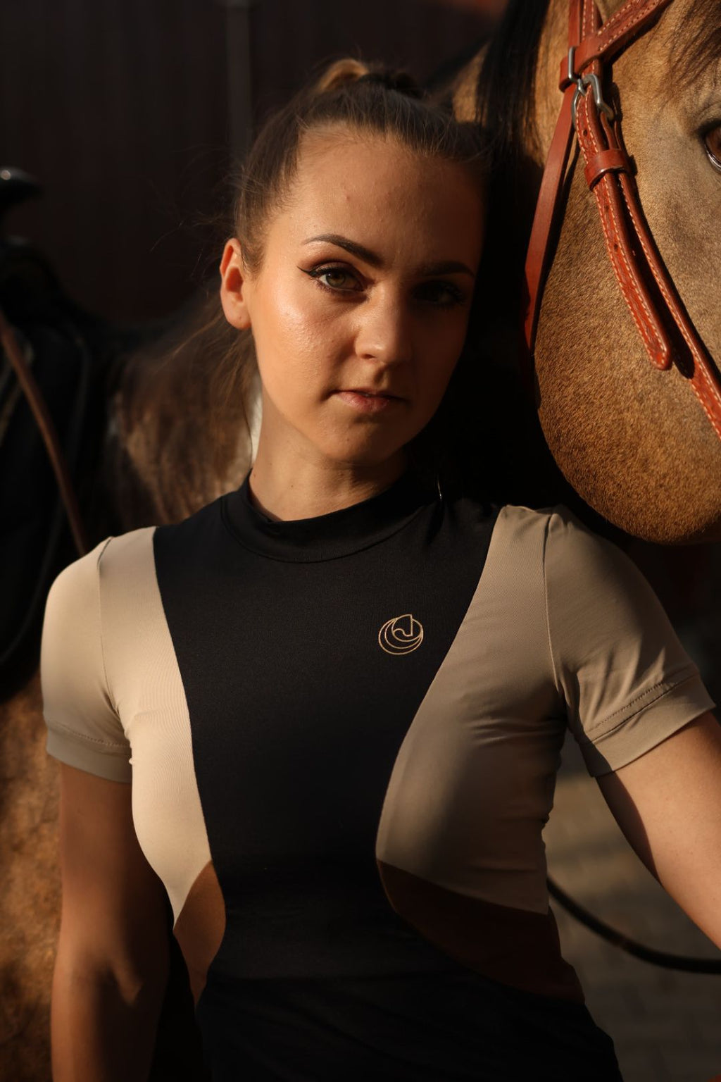 Horse Spirit Riding Top Line Black in black, beige, and brown - Front view on model showing the distinctive HORSE Spirit motif, premium Italian fabric, and rich, earthy color palette.