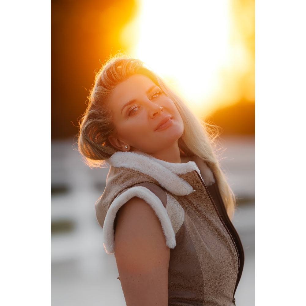 Side view of a woman wearing the fitted Horse Spirit Warrior vest in Beige, showing how the garment moves with the body and maintains a sleek, feminine curve from every angle.